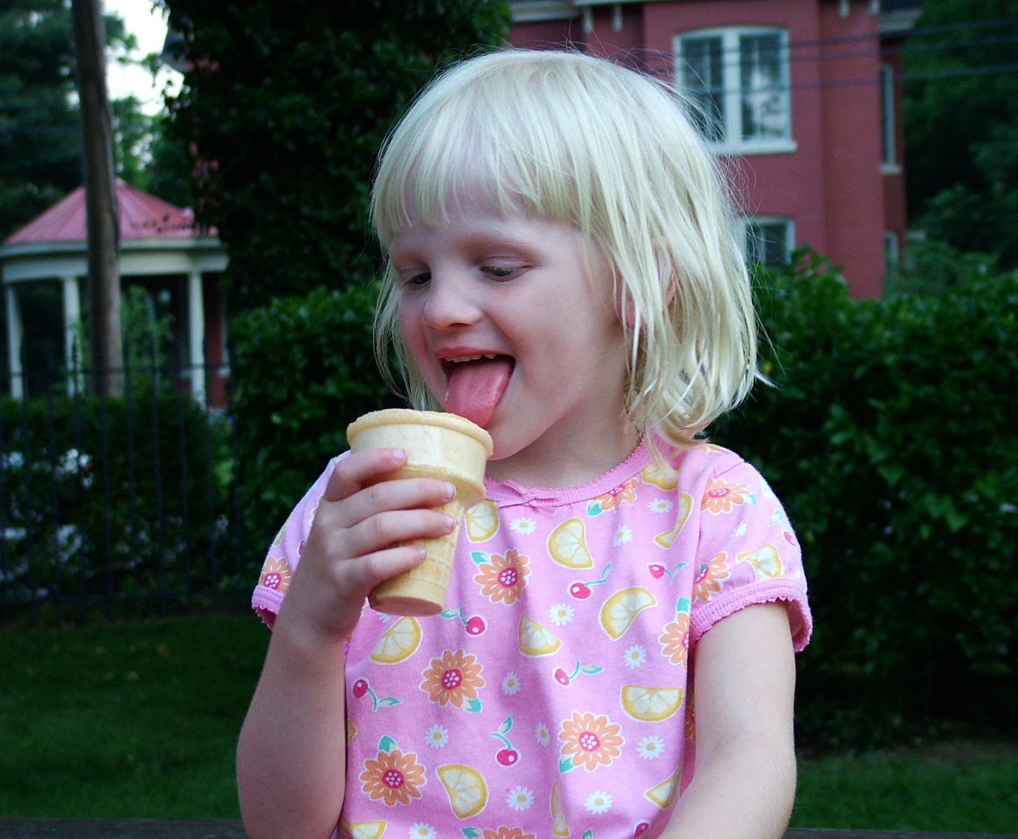 small child eating a piece of food outside