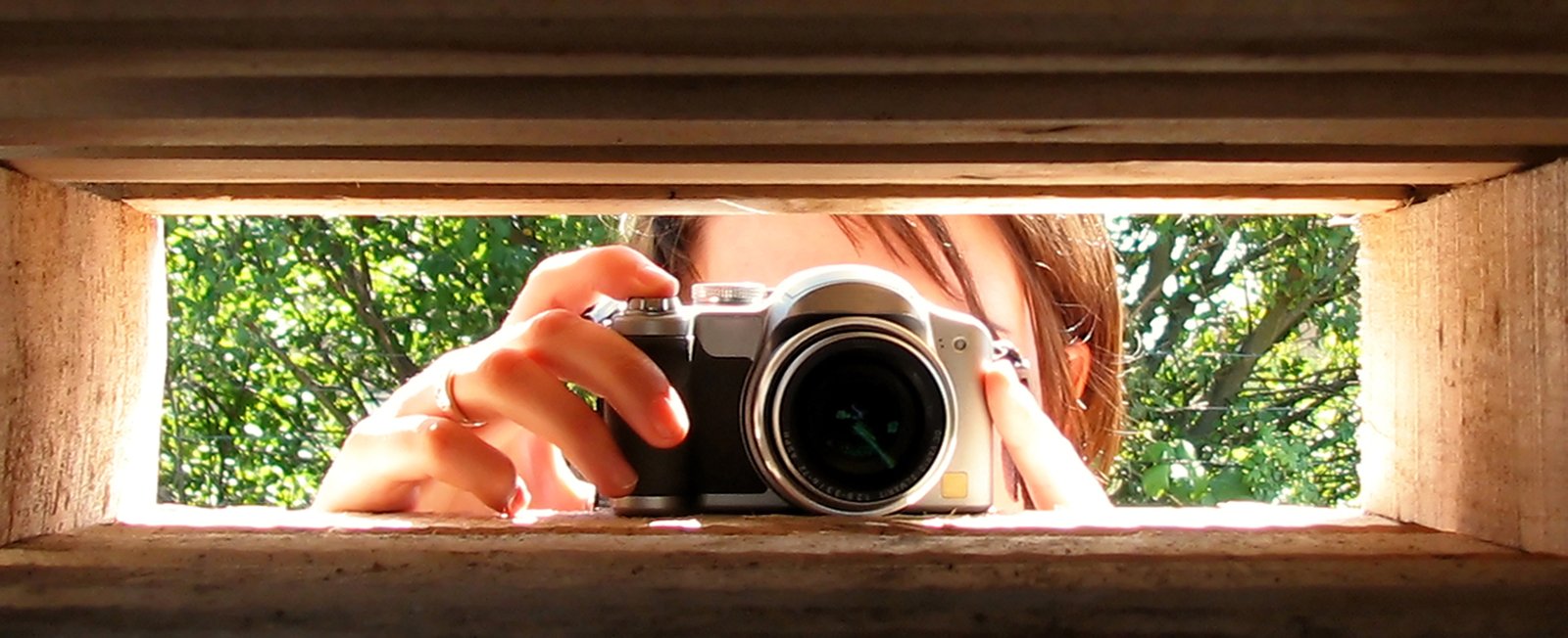 a girl taking a picture through a window