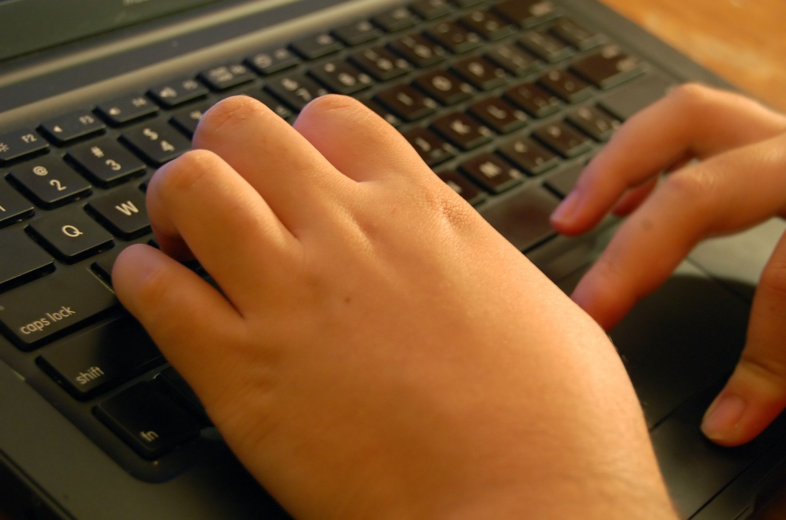 someones hands typing on a computer keyboard