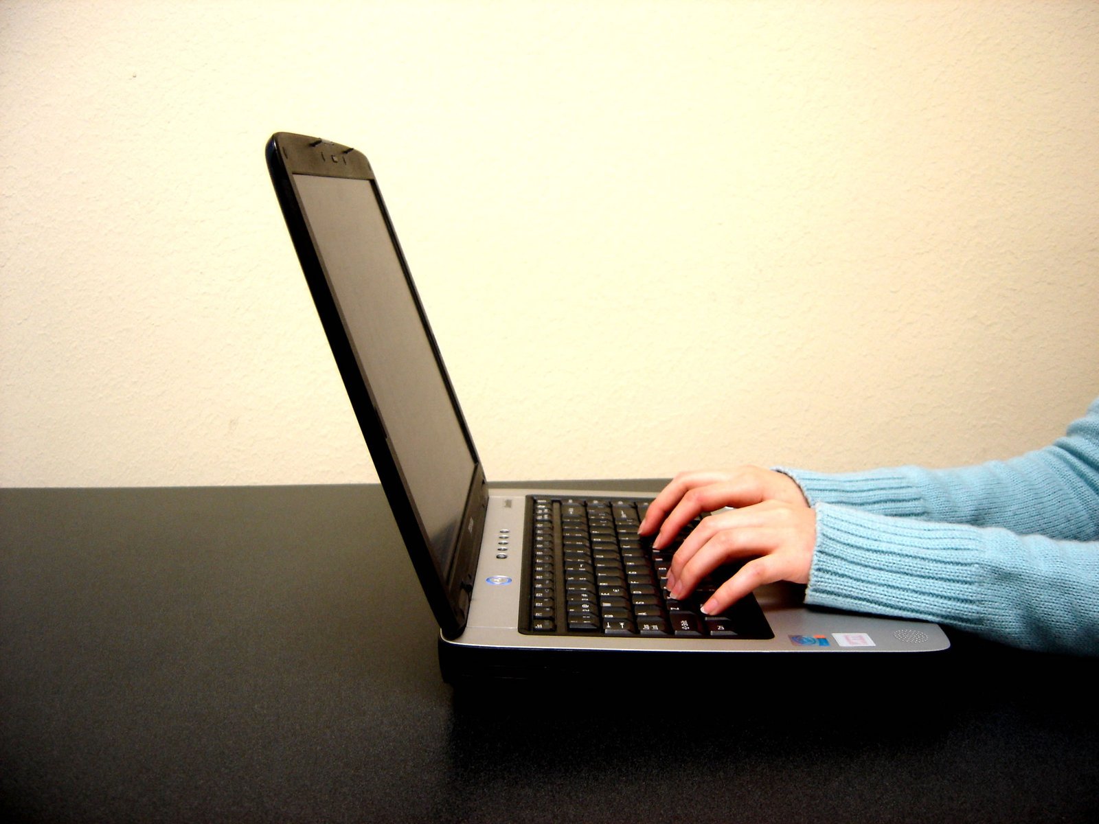 someone typing on a laptop computer at a table