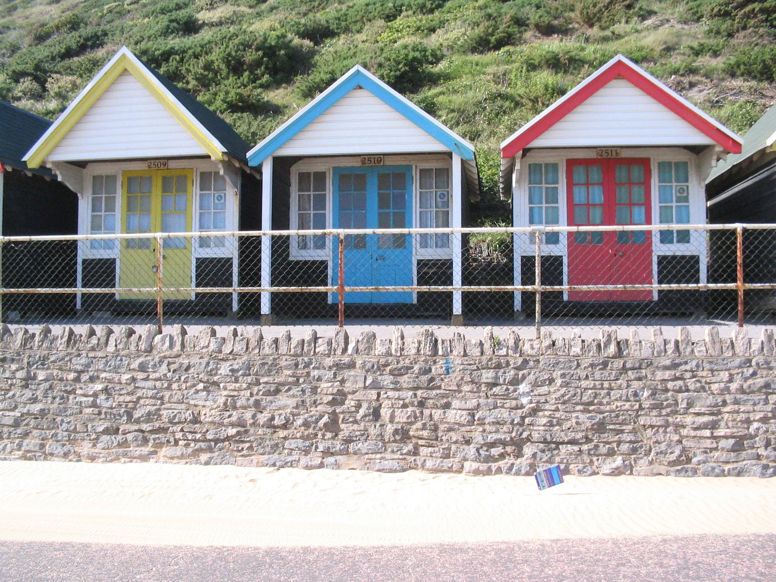 some little colorful beach huts in the grass