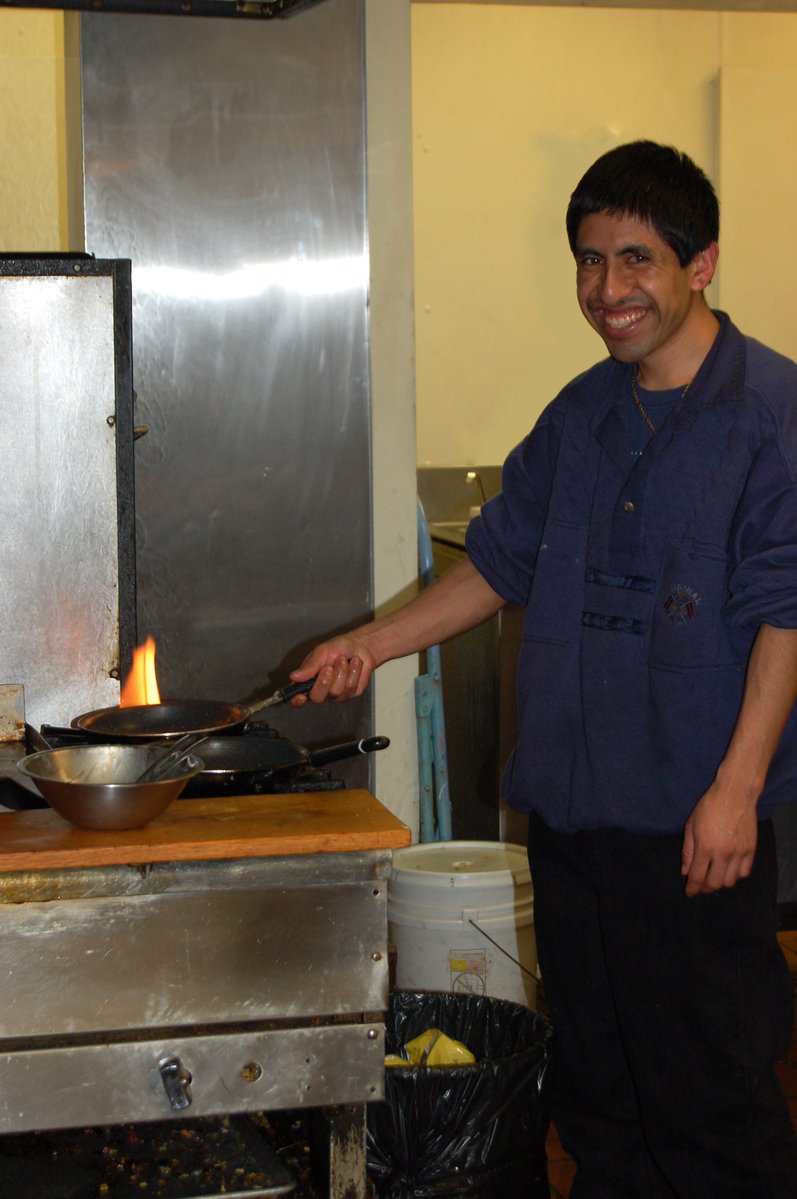 a man standing in a kitchen holding a frying pan