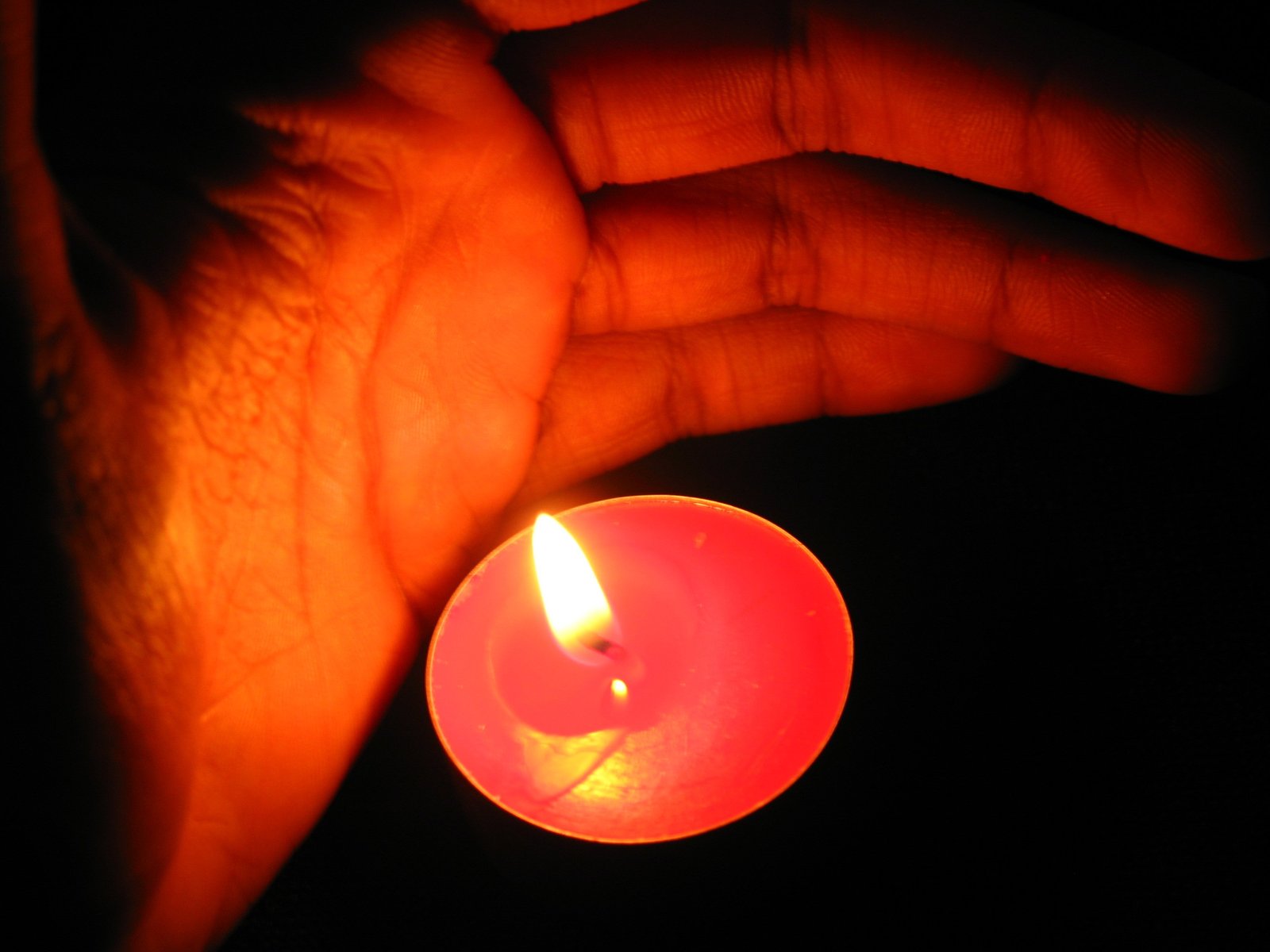 an open hand with a lit candle in it