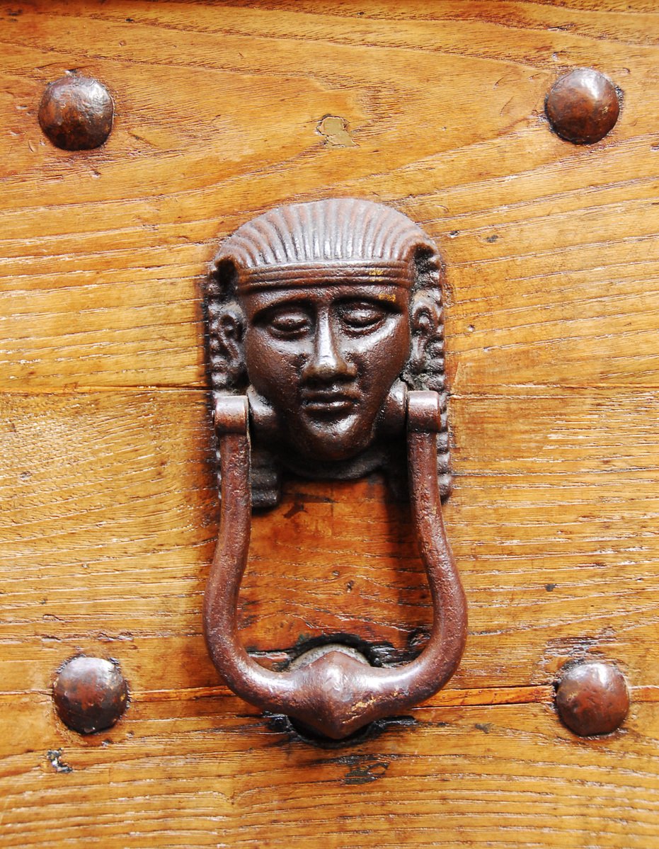 an iron latch on a wood door with metal s