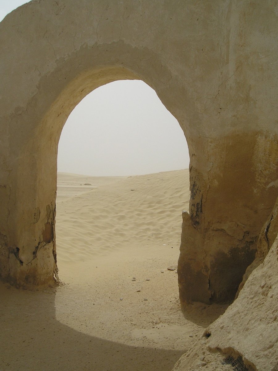 a very big arch in a rock in the desert
