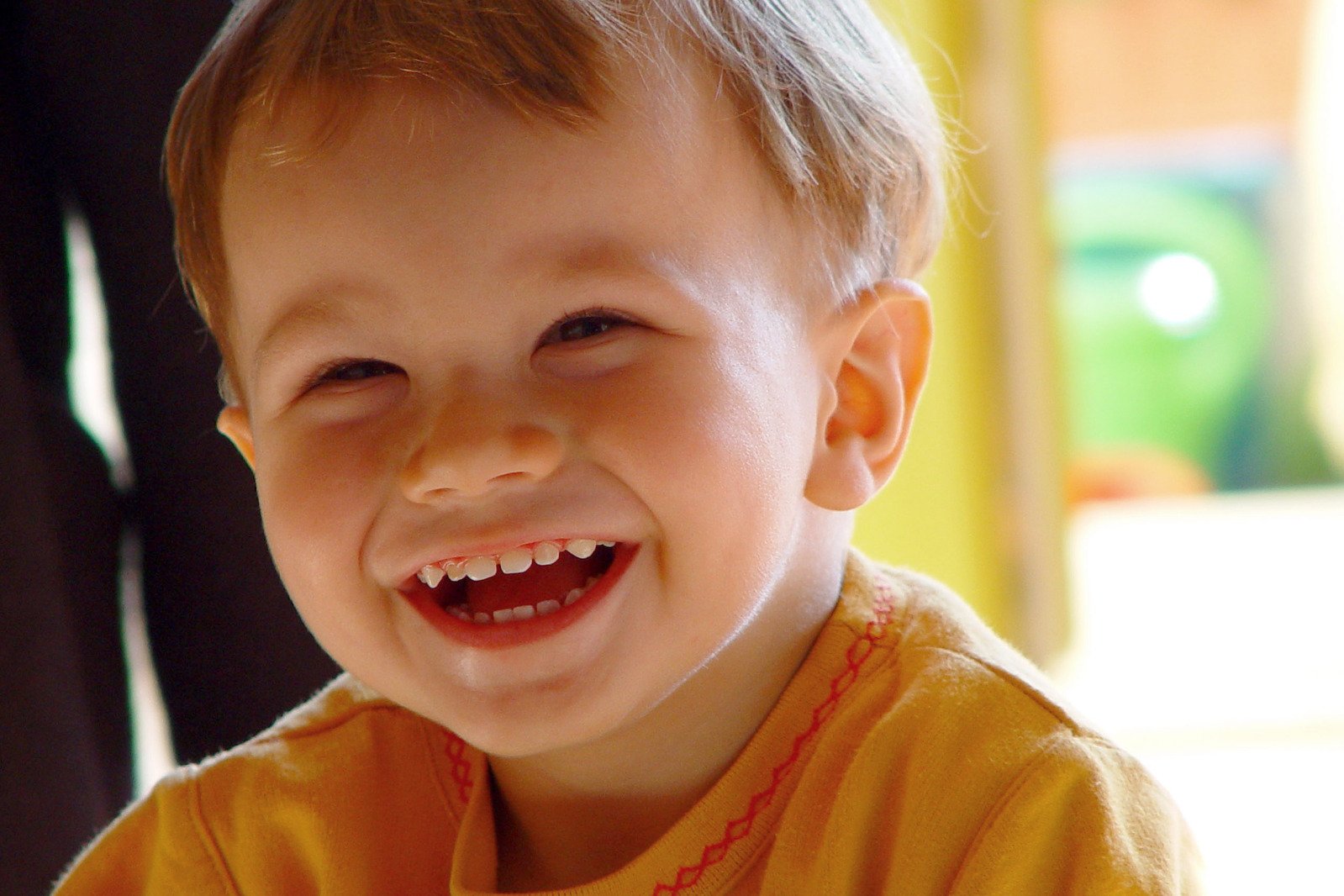 a close up of a child smiling for a picture