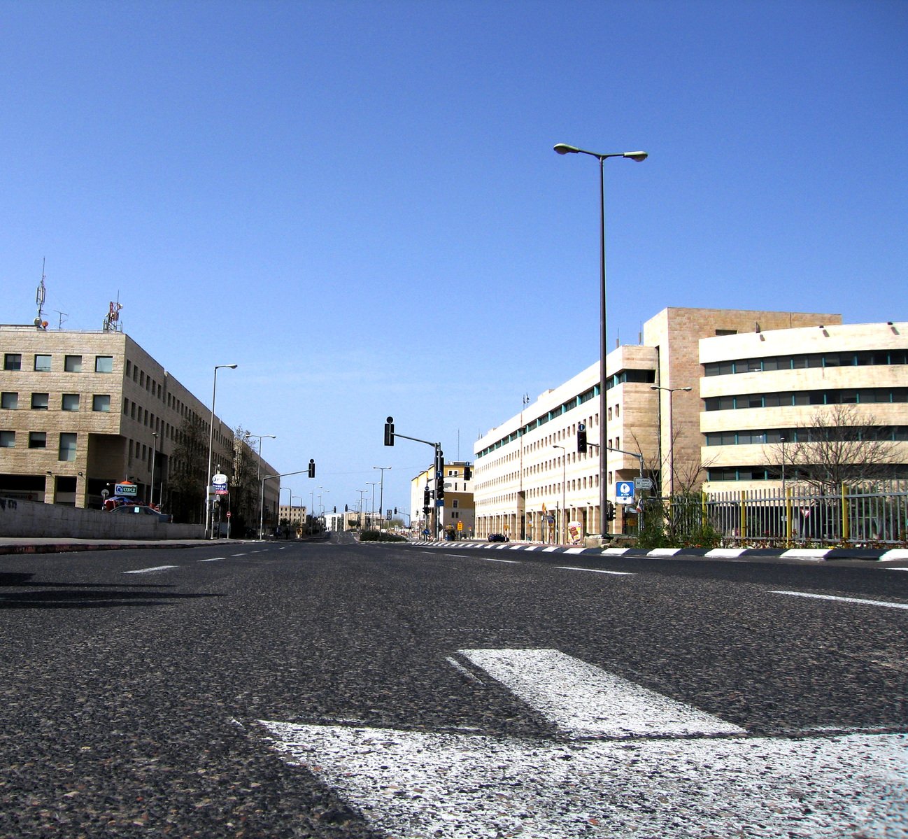 a road near two large buildings on a sunny day