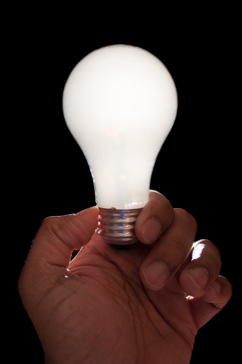 a person is holding up a light bulb