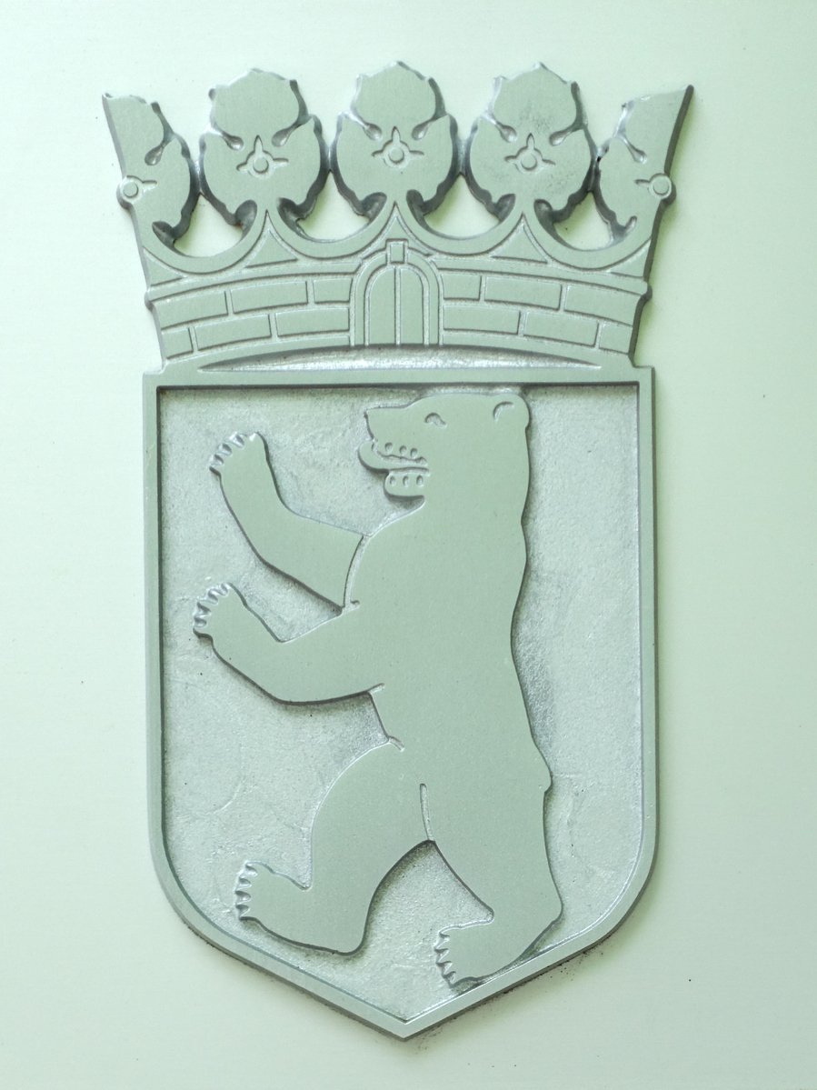 a wall mounted emblem depicting a bear with a crown