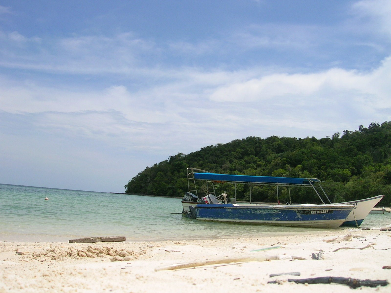 a boat on a beach in front of a hill