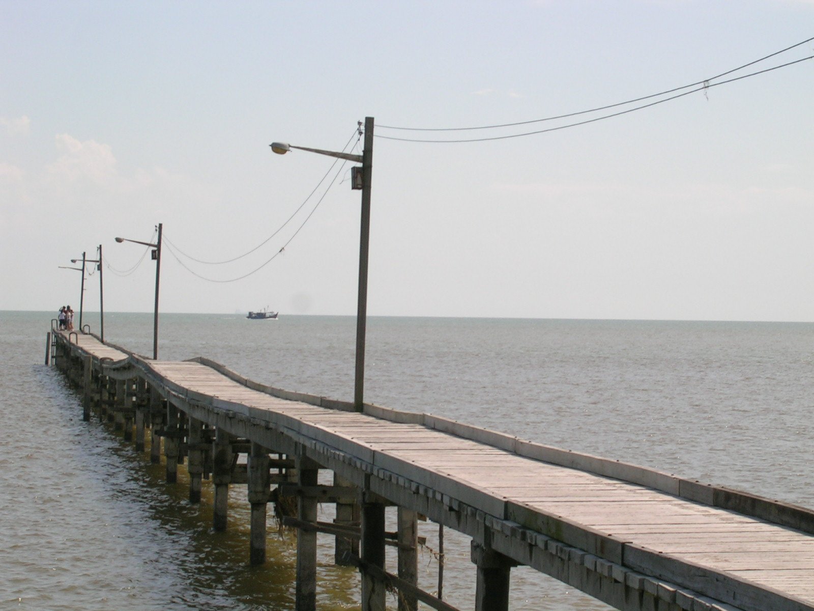 a pier extending into the ocean with some people on it