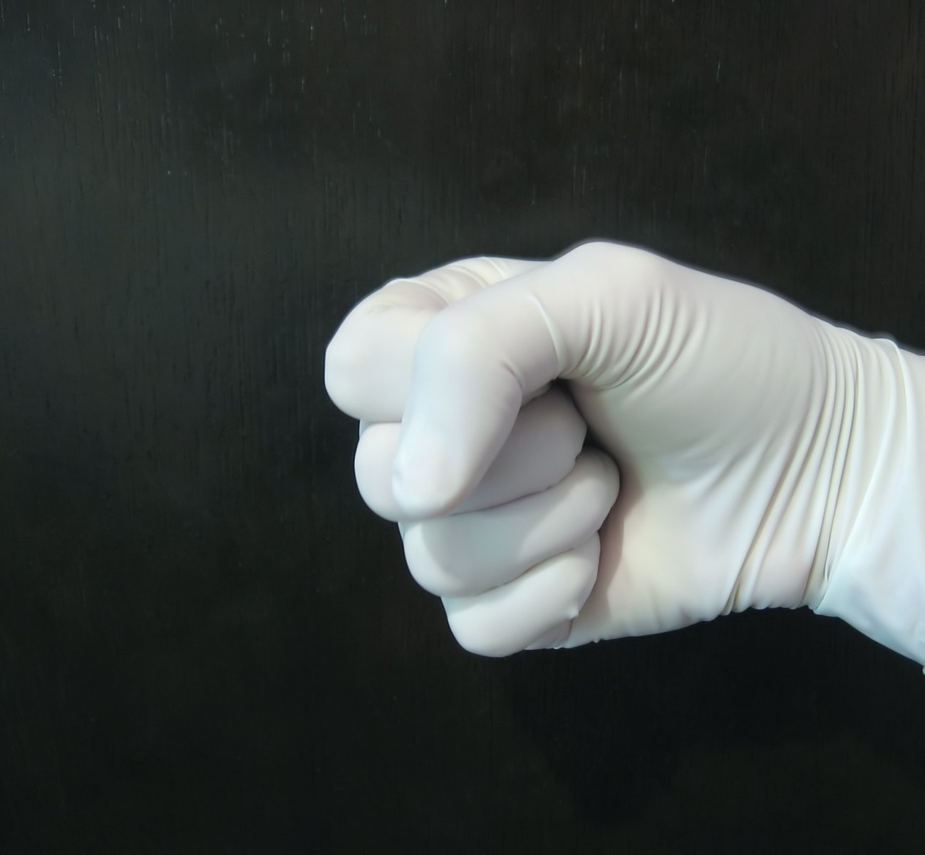 a hand wearing a white glove pointing in to the sky