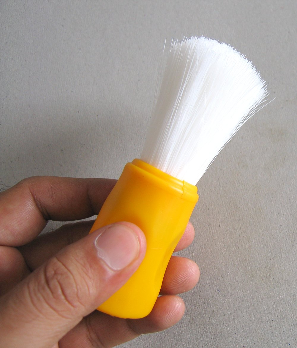 the yellow brush is in a persons hand