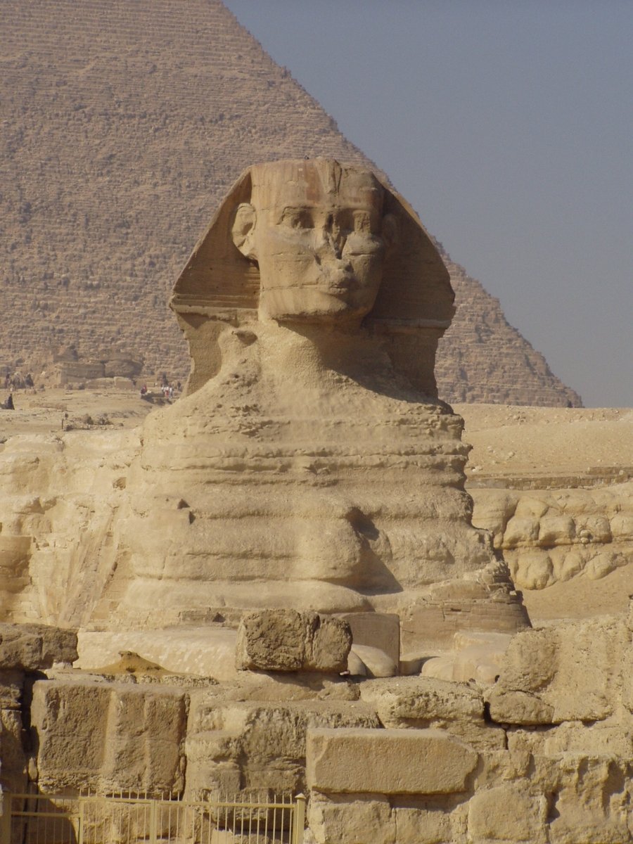 an old sculpture sitting in front of the pyramid