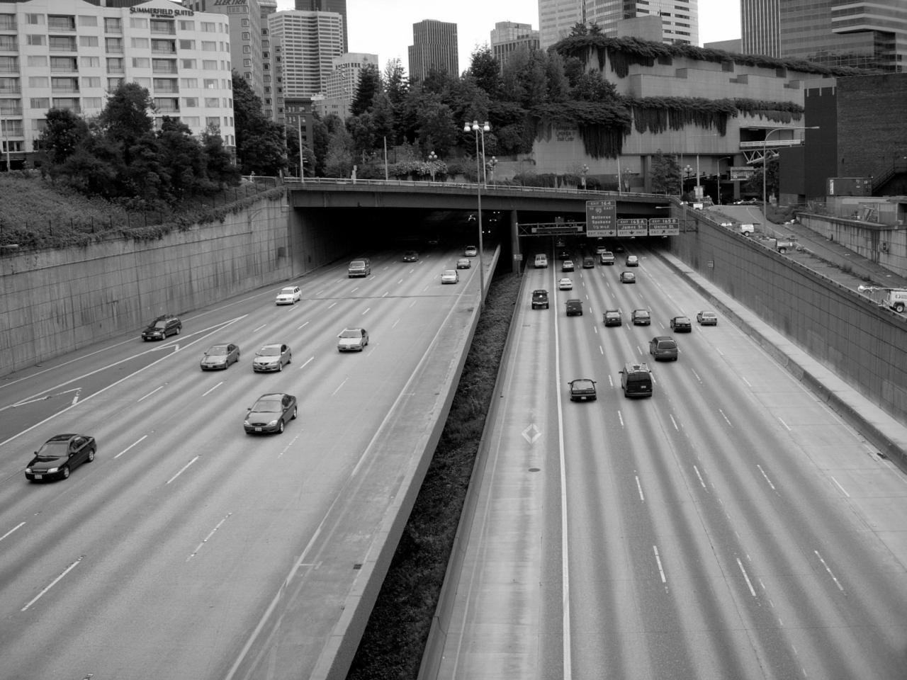 cars on a freeway near city buildings and traffic lights