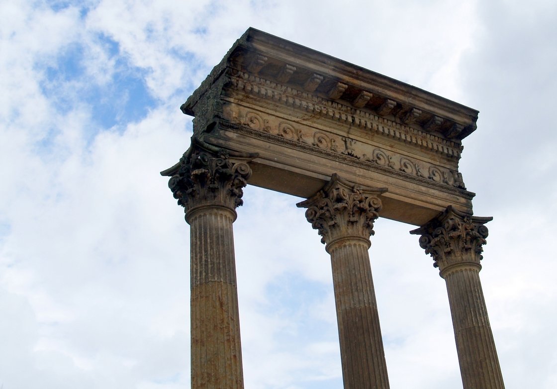 four stone pillars in front of a blue sky