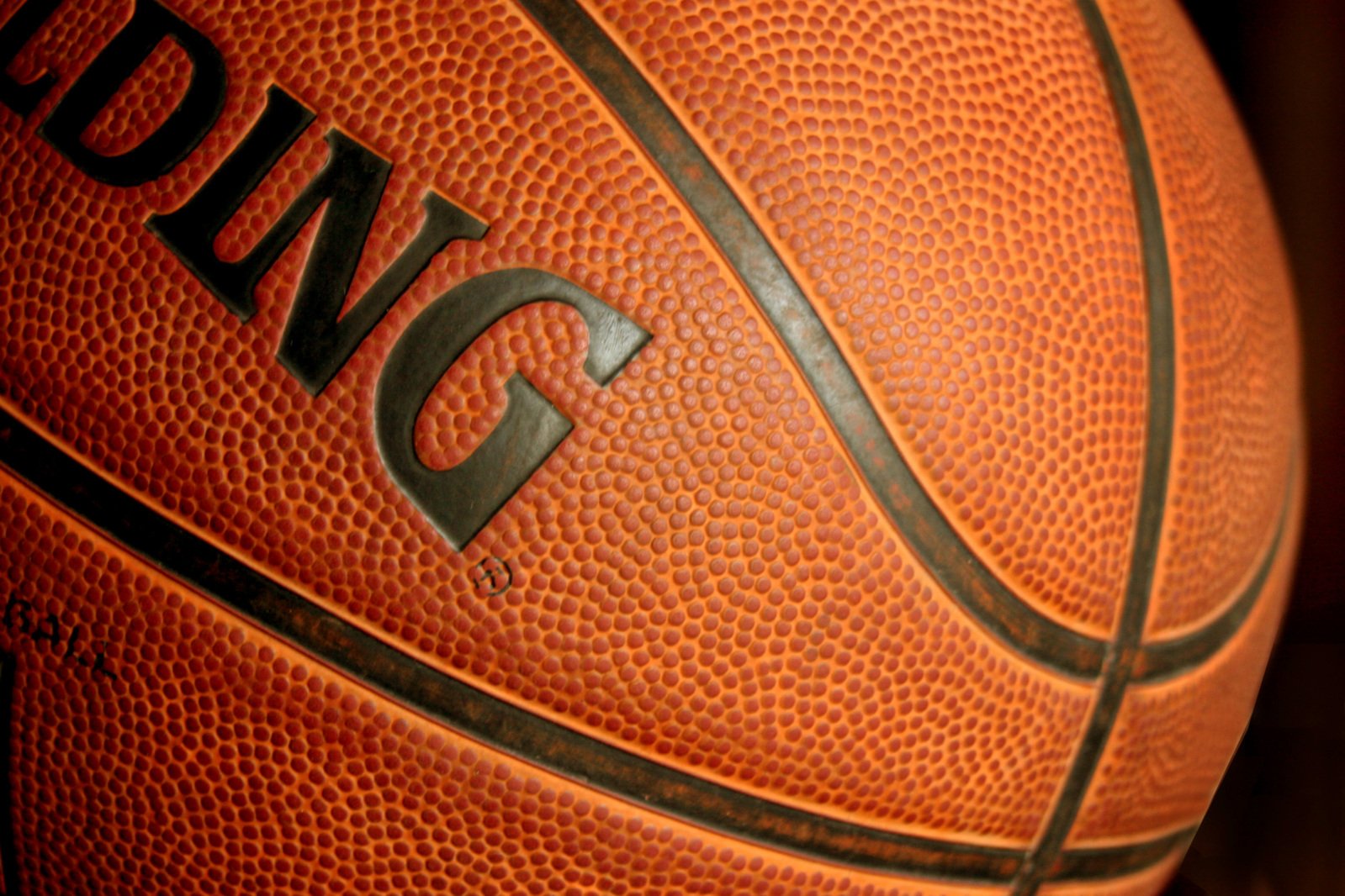 closeup of an orange basketball with the initials on it