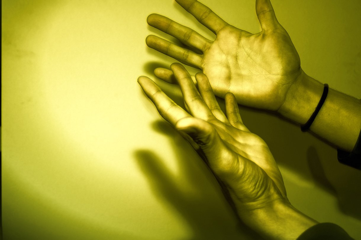 two hands reaching towards one another with a light background