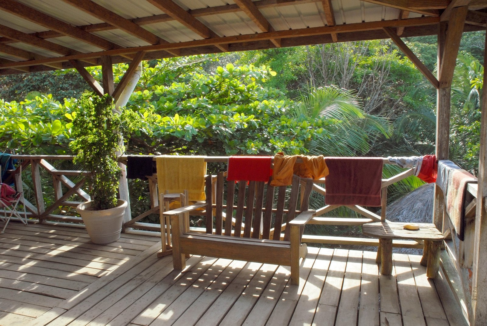 the sun shines on chairs outside a wooden deck