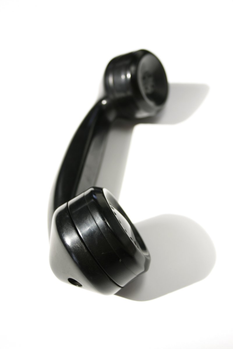 a telephone with black cords and two plugs