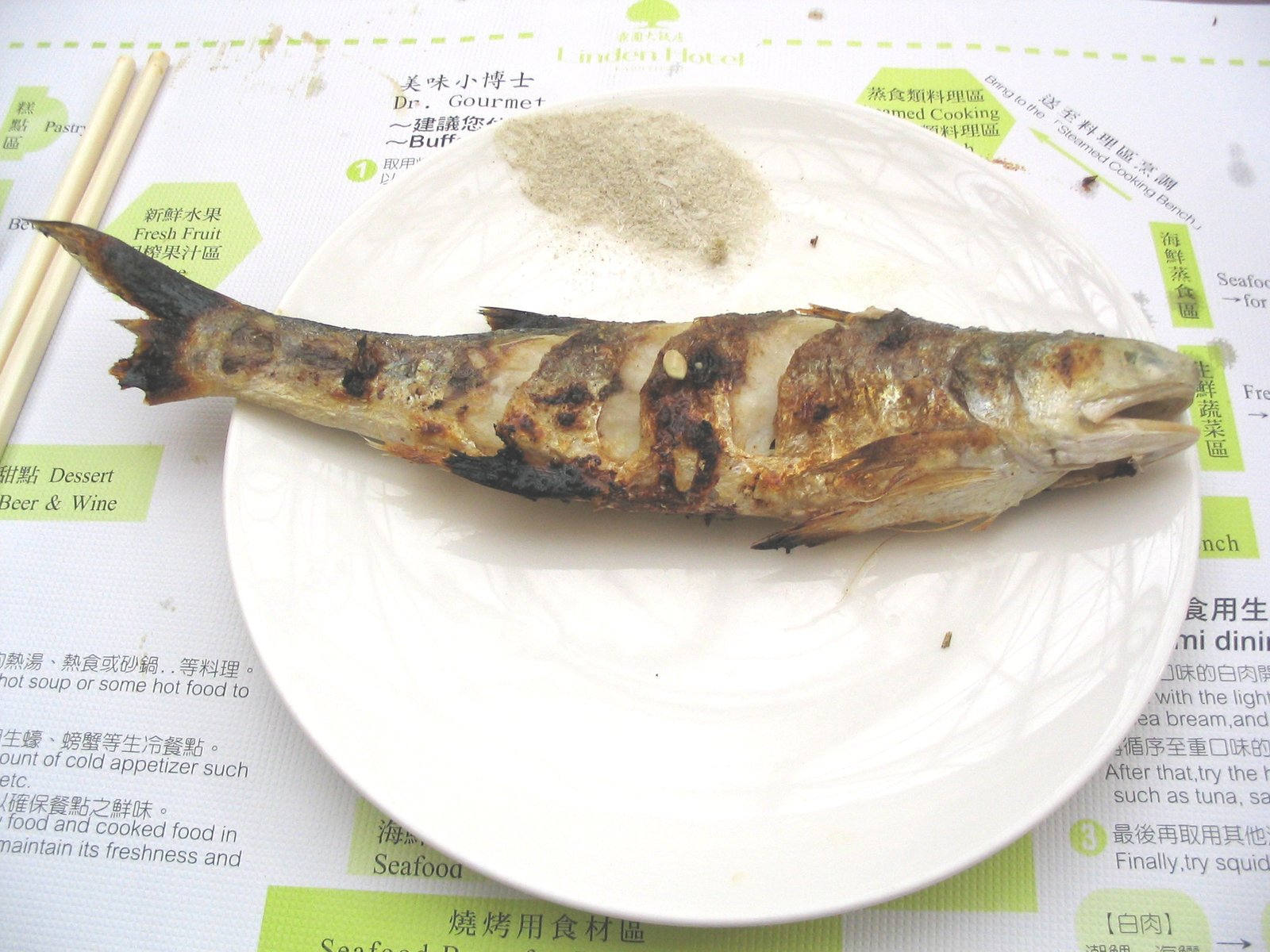 some type of fish on a plate with a chopstick