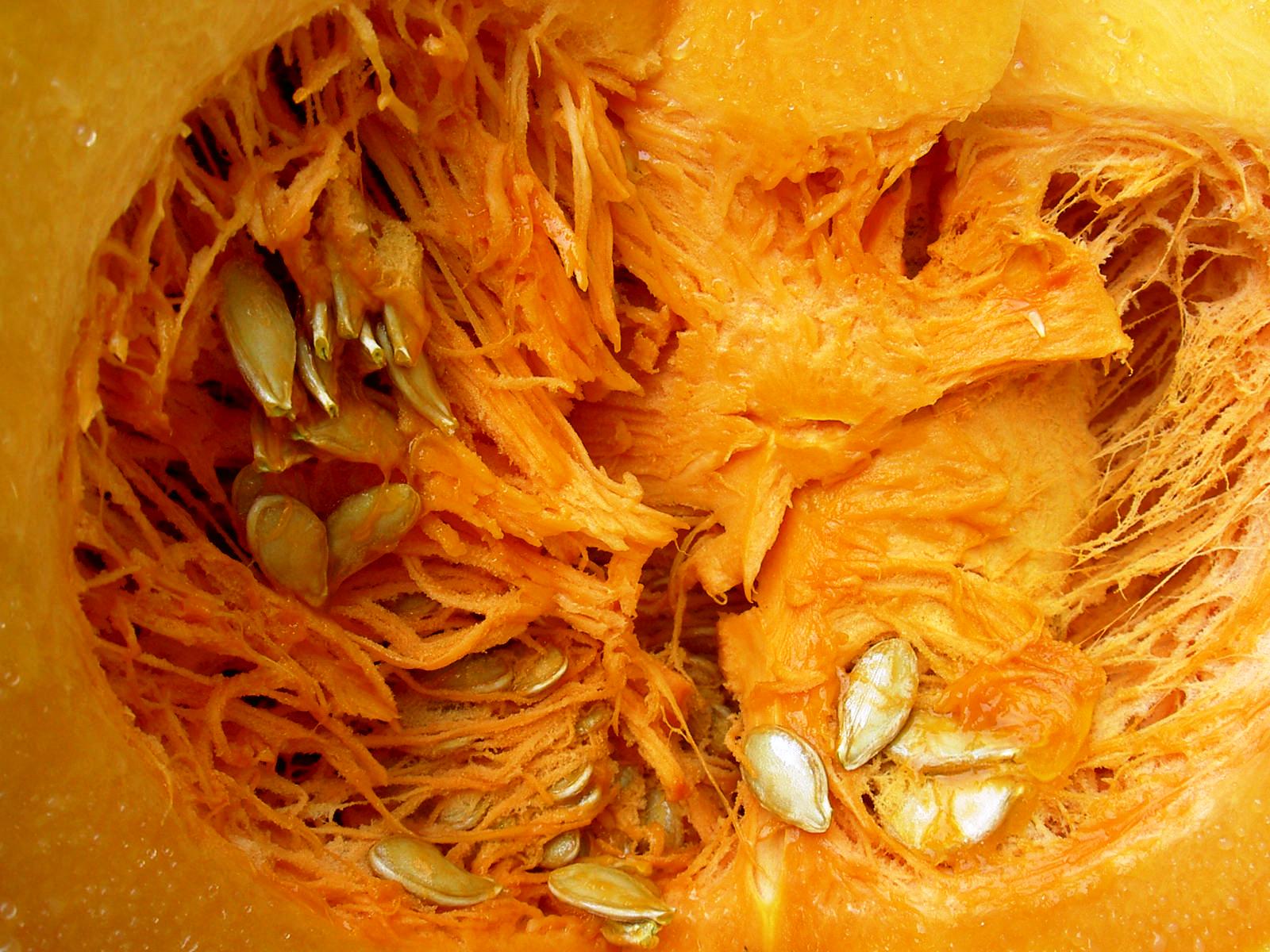 a sectioned up pumpkin is seen with seeds
