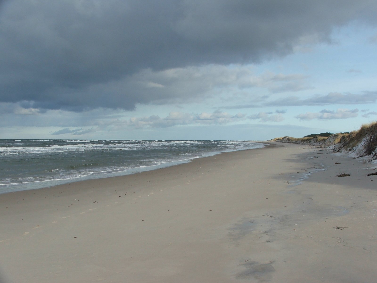 a cloudy day with waves crashing in to the shore