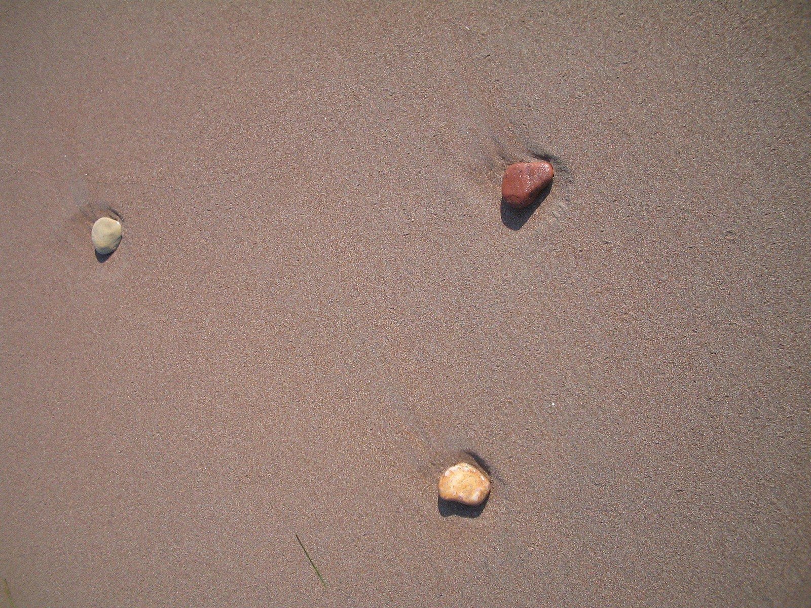 two rocks placed in sand next to each other