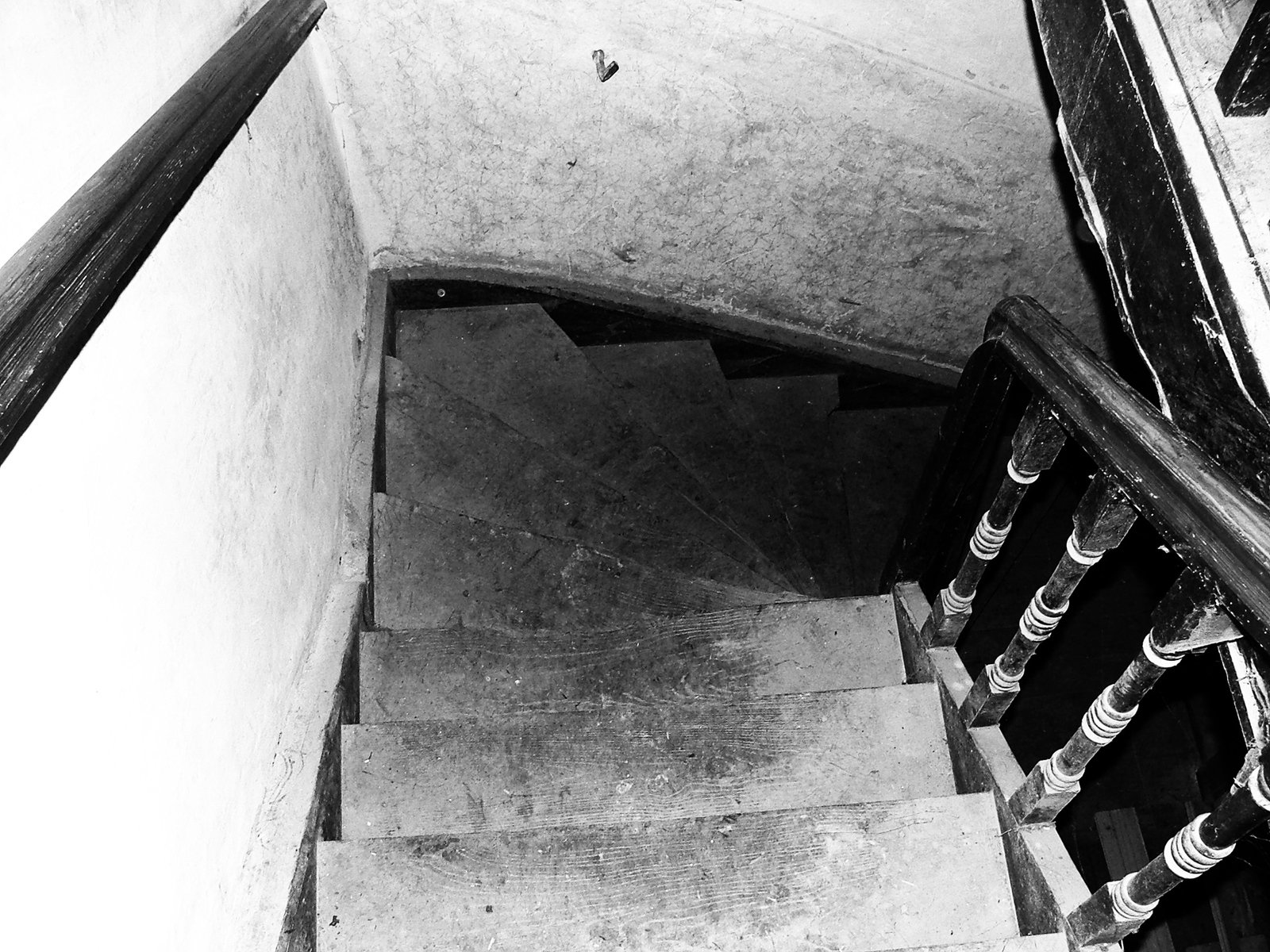 the top of a stair case with a concrete wall