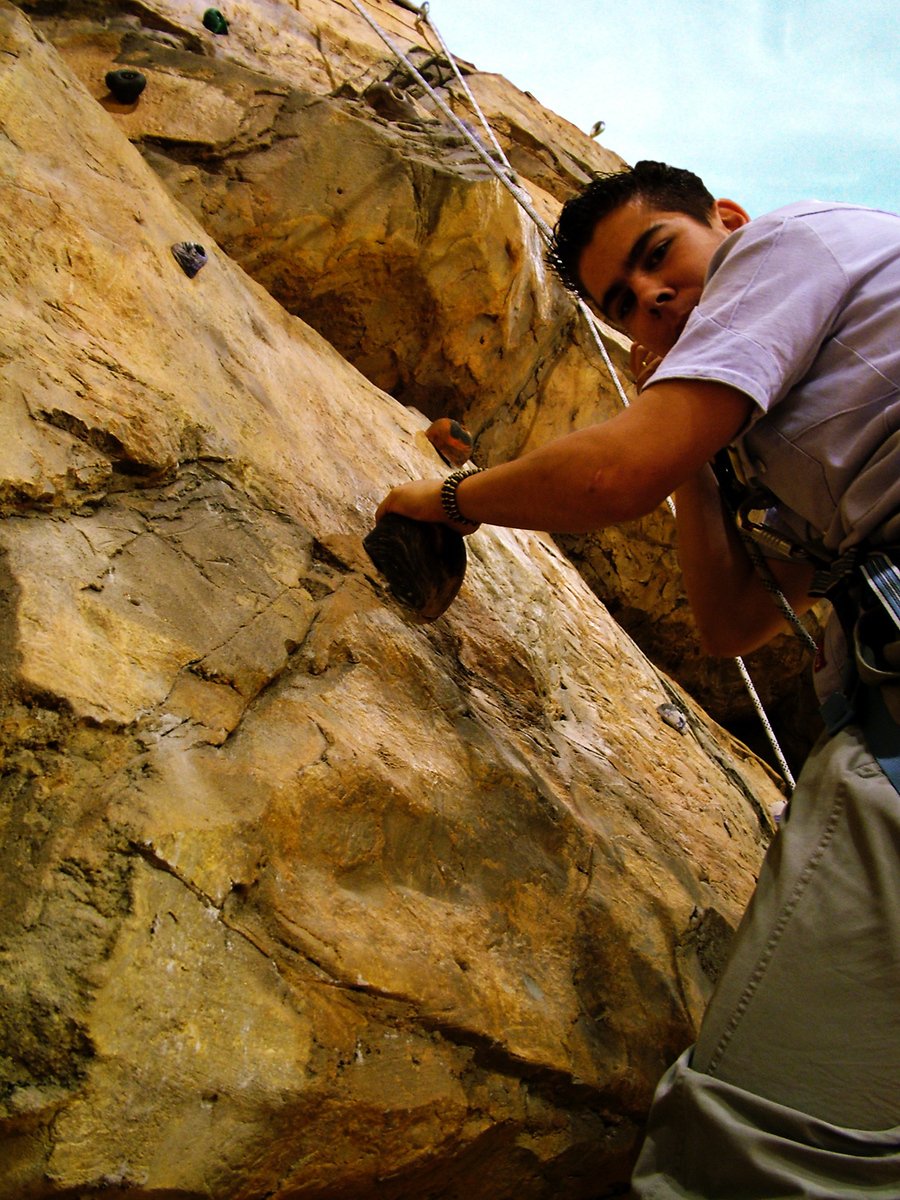 a man climbing up the side of a mountain