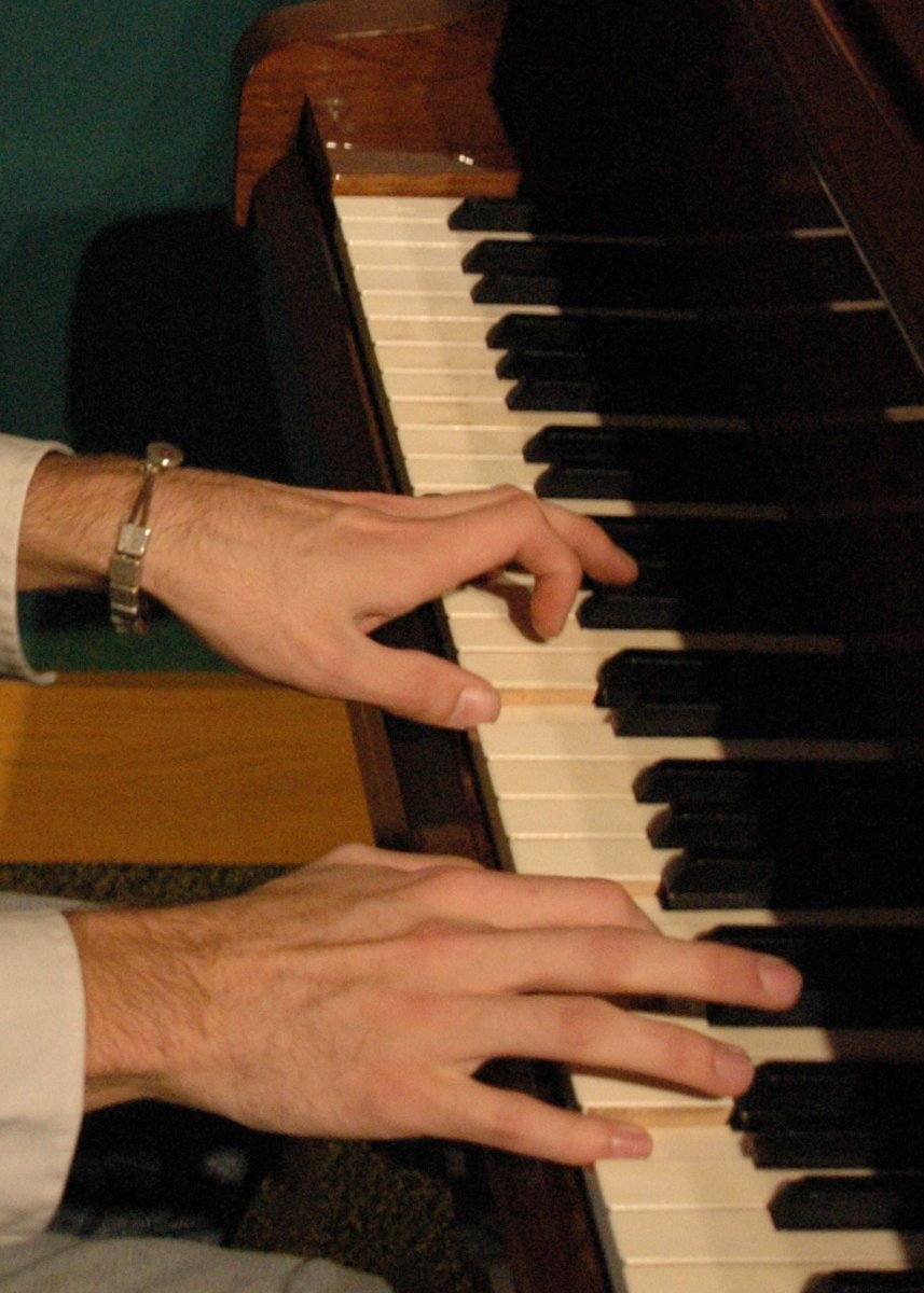 two hands holding on to an electronic keyboard