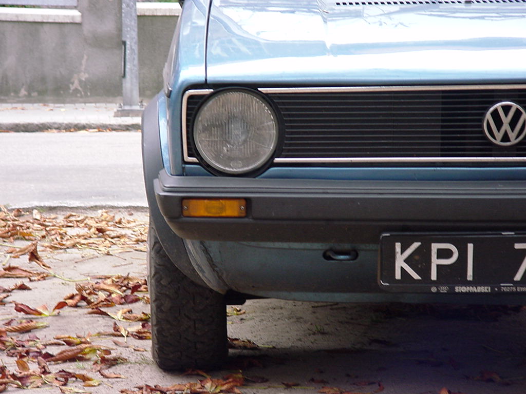 the front view of a car parked near a curb