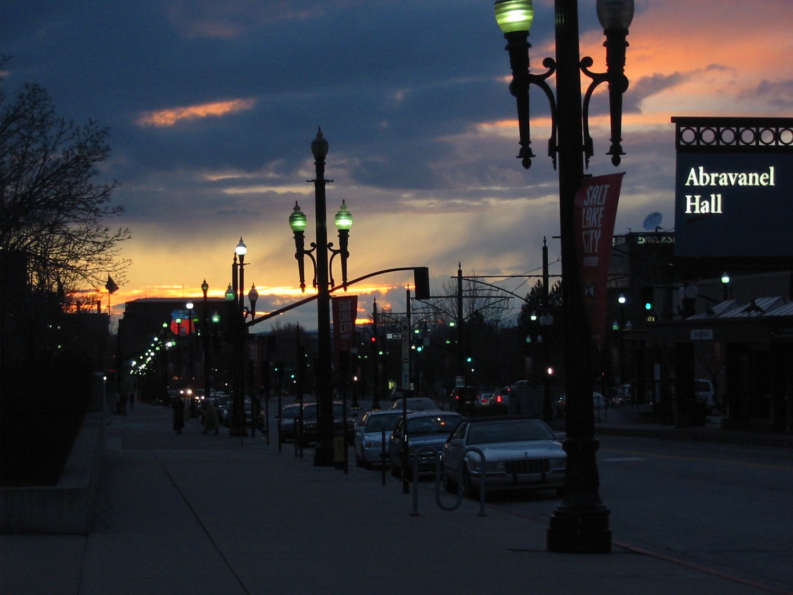 street lights line a sidewalk during sunset