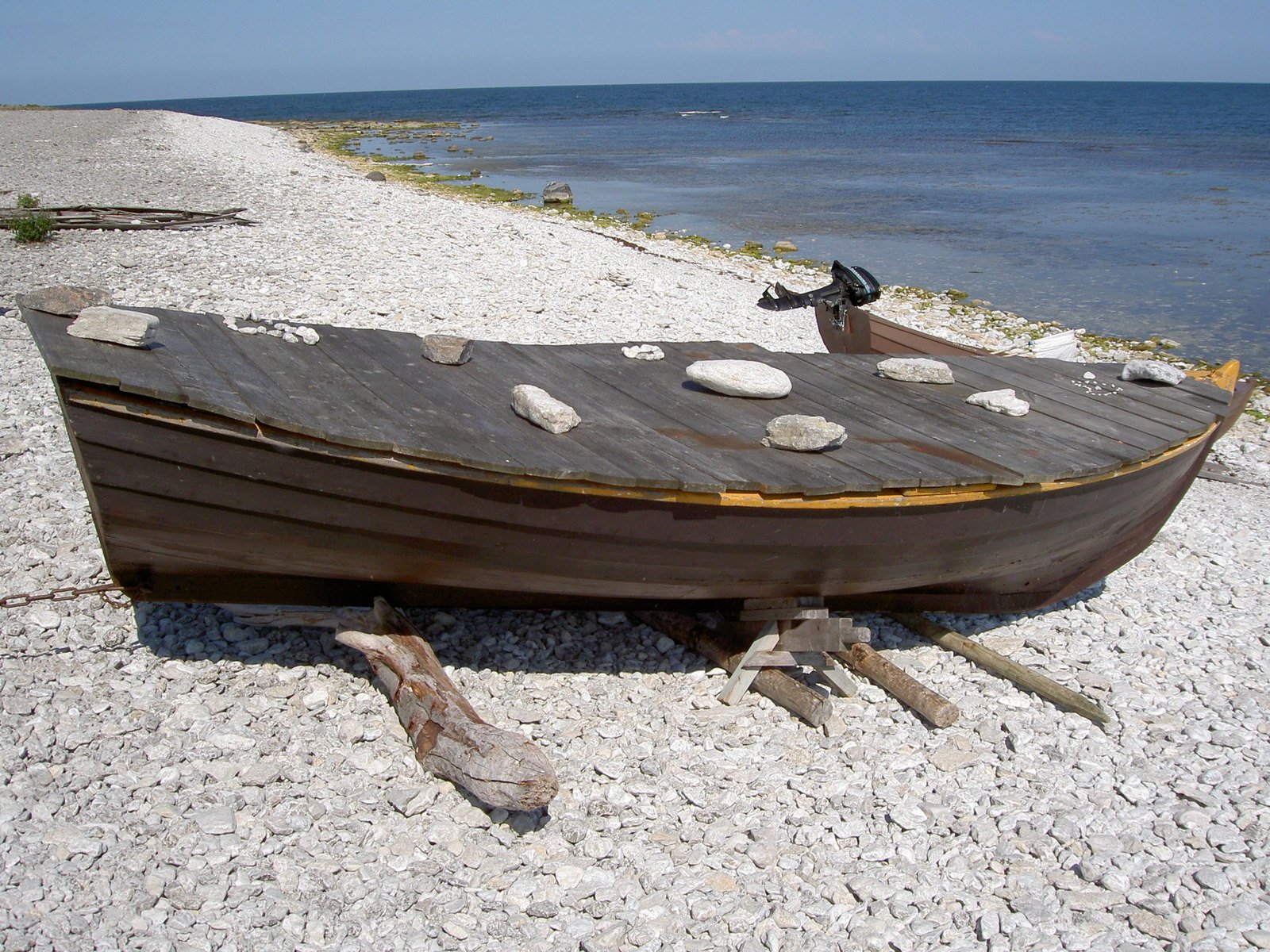 a large wooden boat laying on top of sand