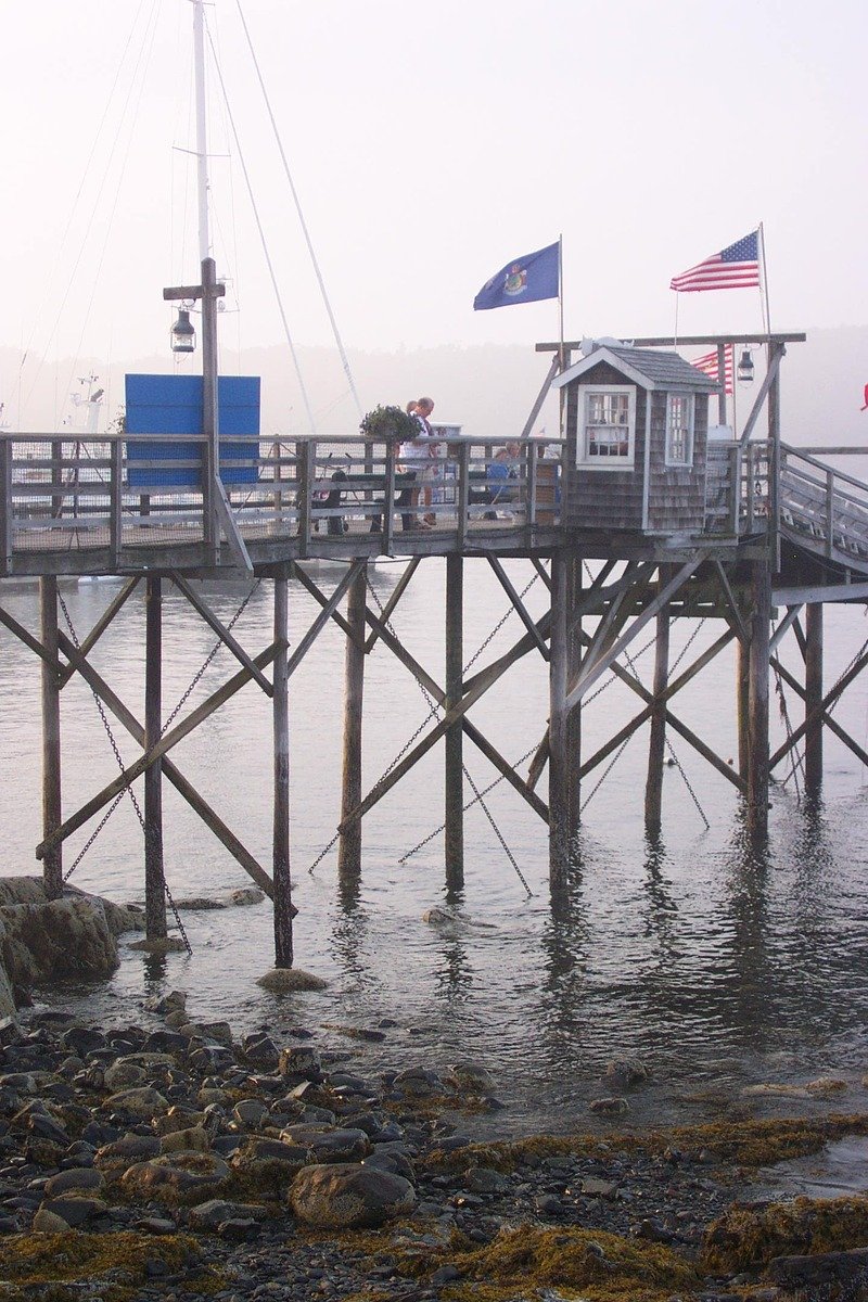 small house sitting on the dock of a body of water