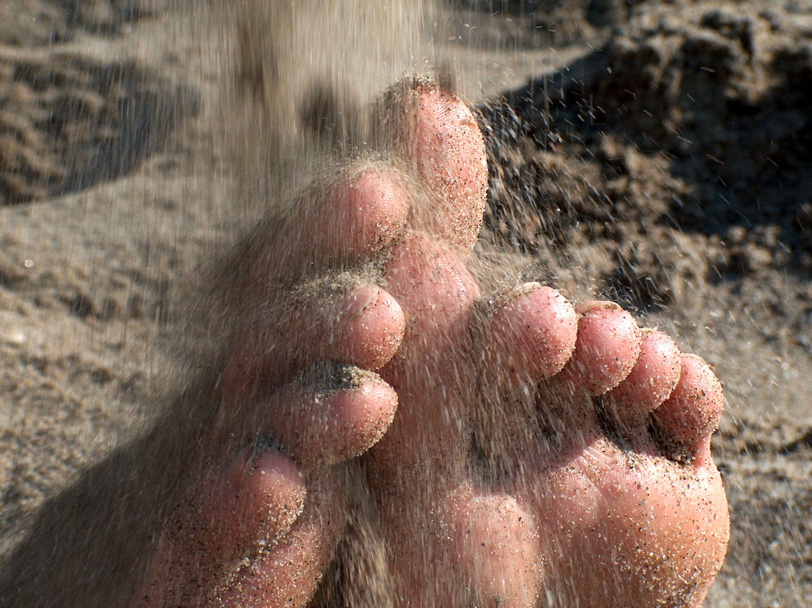 the bare feet and toes of a beach