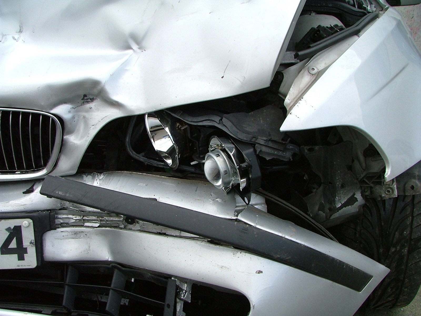 a white car with a wrecked front fender