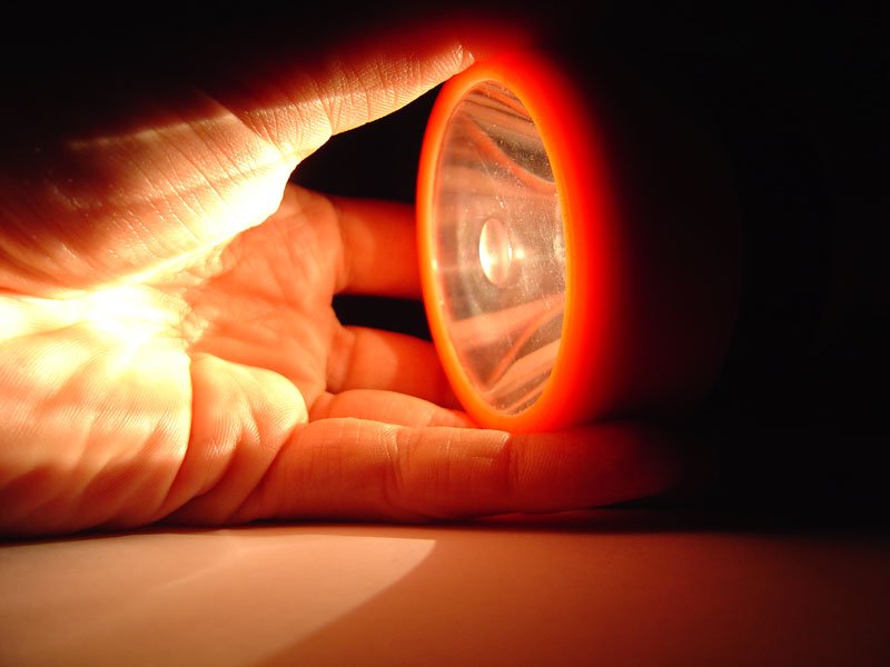 a hand holds an orange plastic light bulb