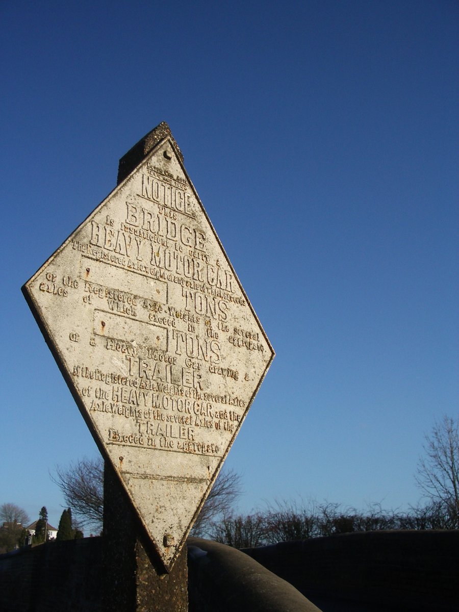 a large white sign on top of a wooden pole