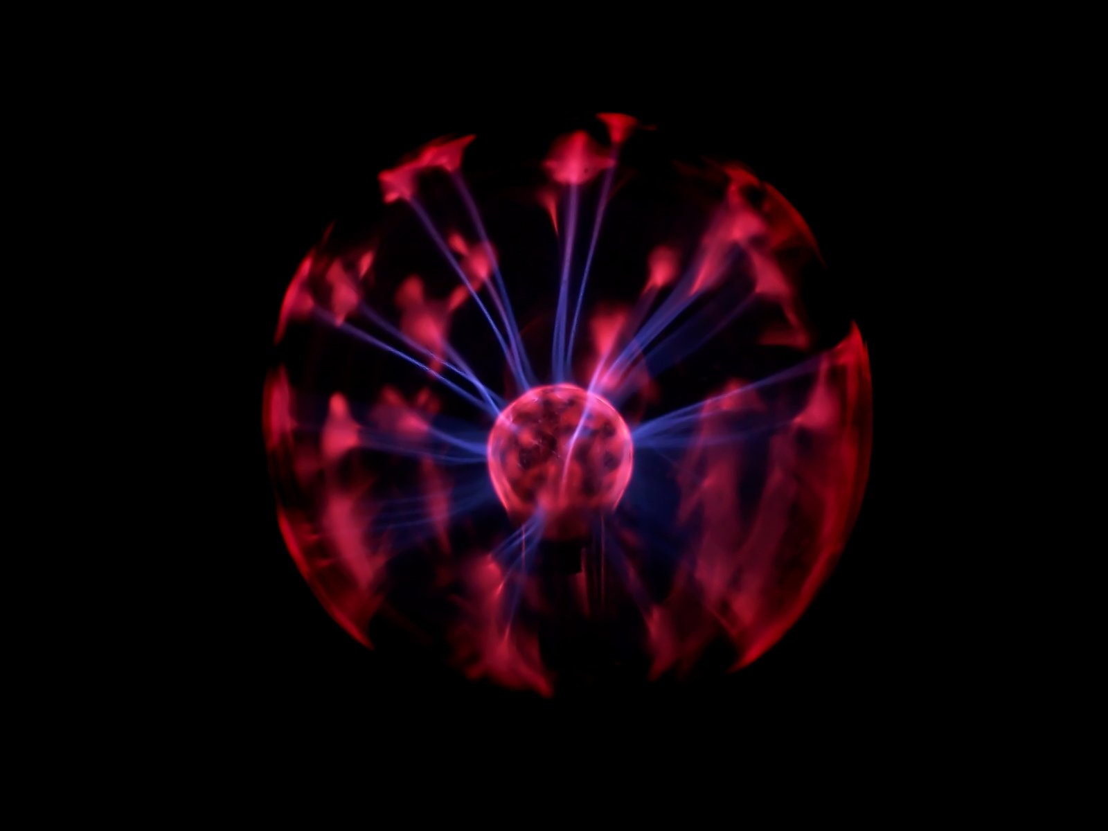 a colorful swirl of light and red blur over black background