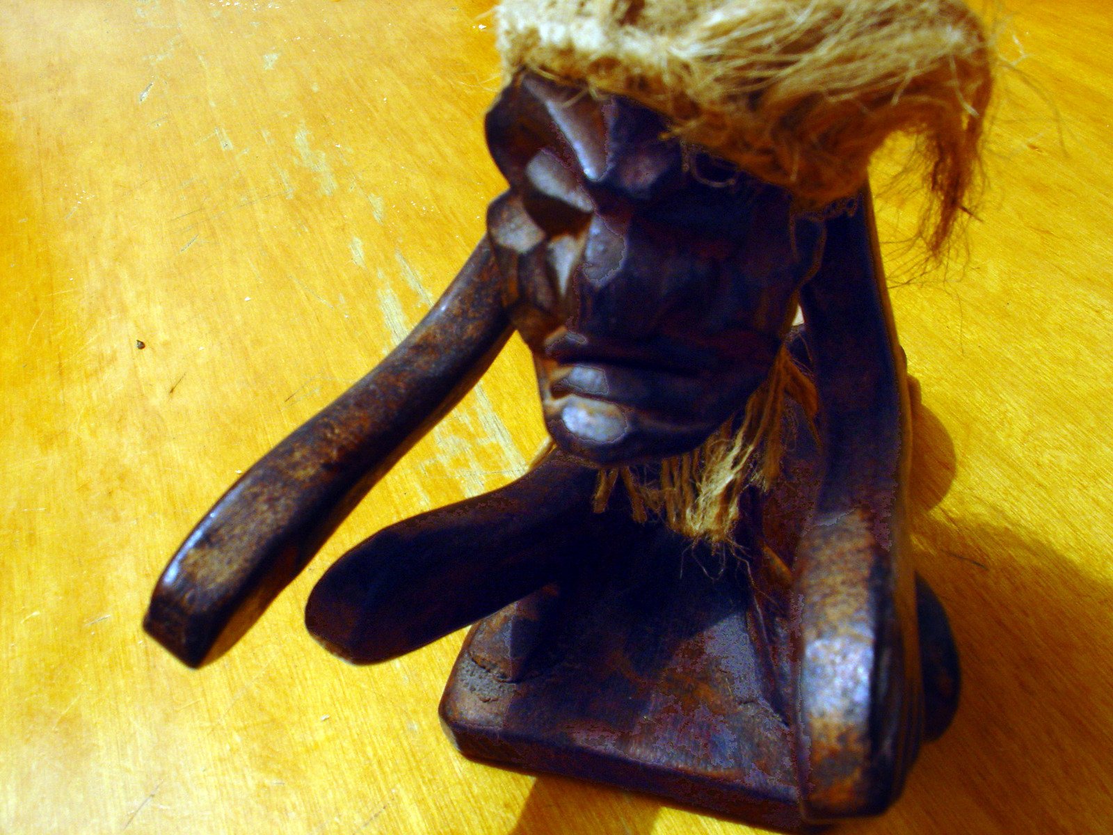 a wood sculpture holding a piece of rope that has been tied to it