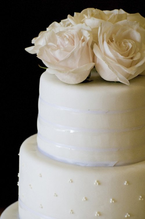 a closeup of a white three layer wedding cake