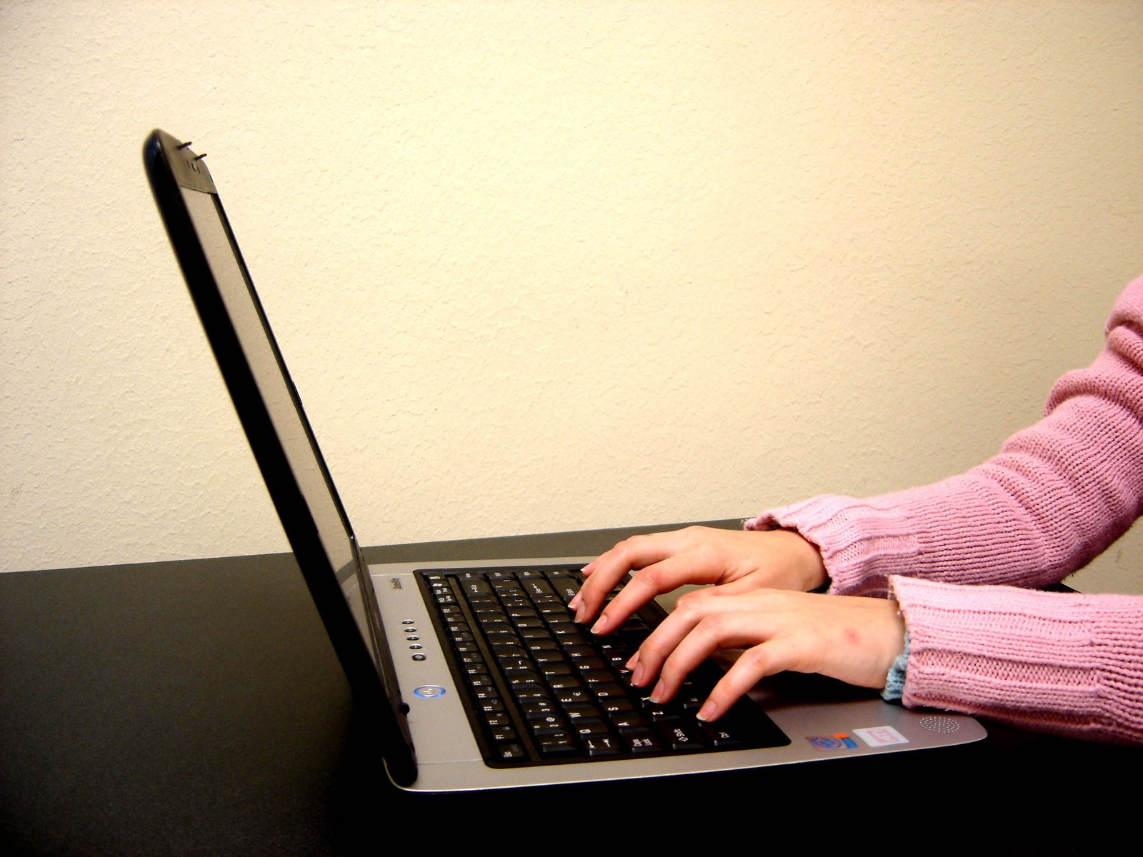 a woman is typing on her laptop computer