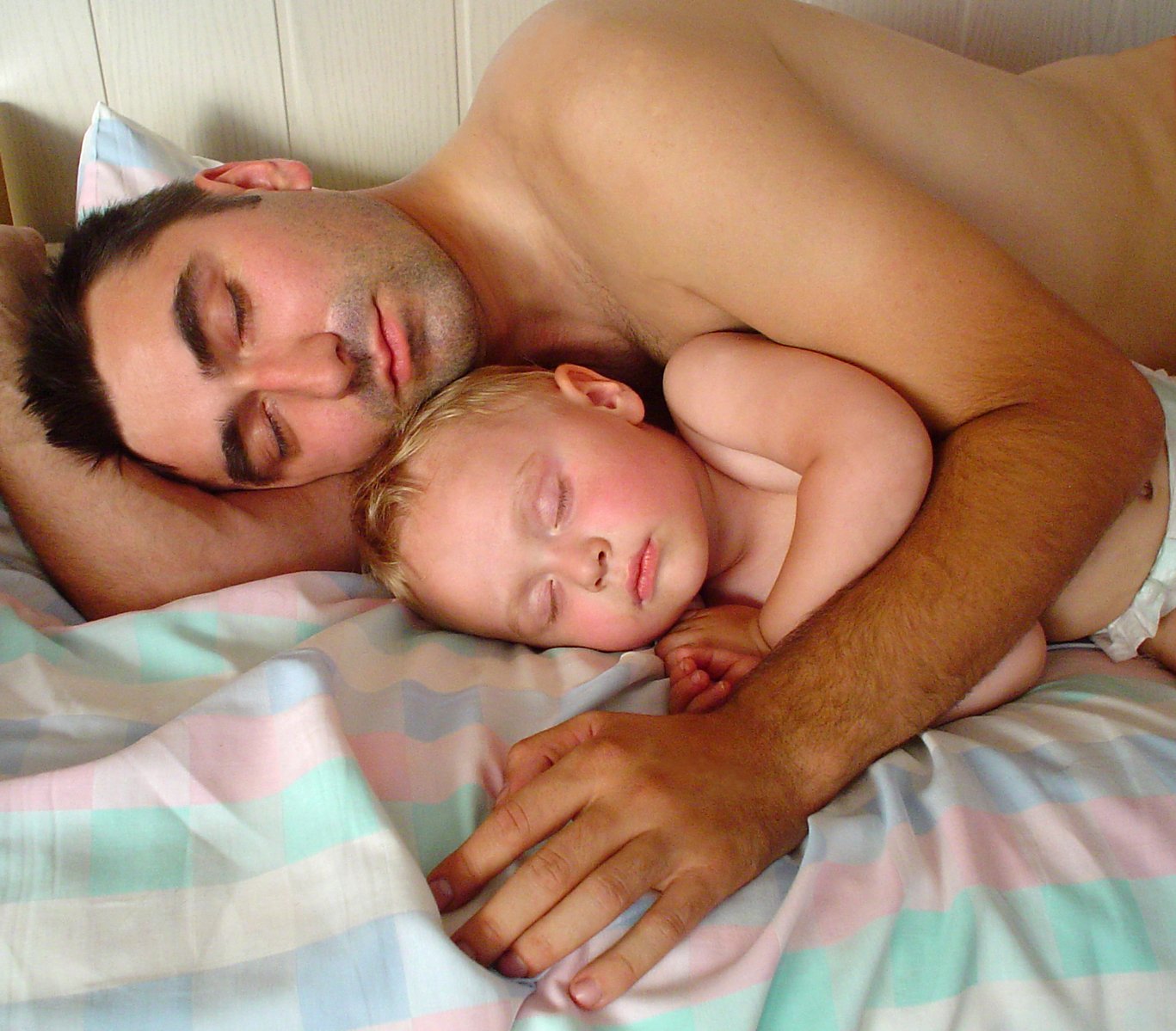 a man and a child laying on a bed