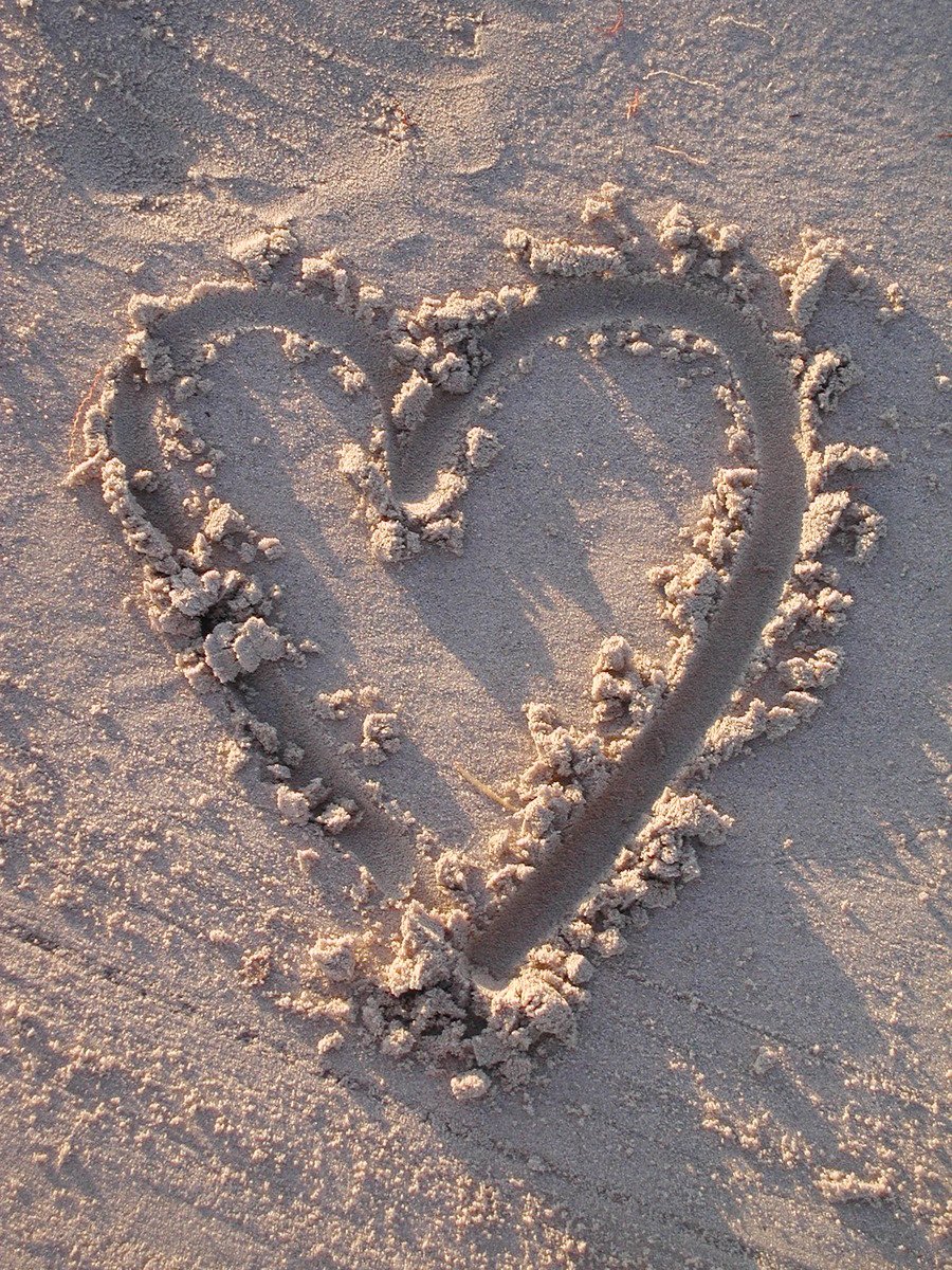 a heart shape made in the sand on a beach