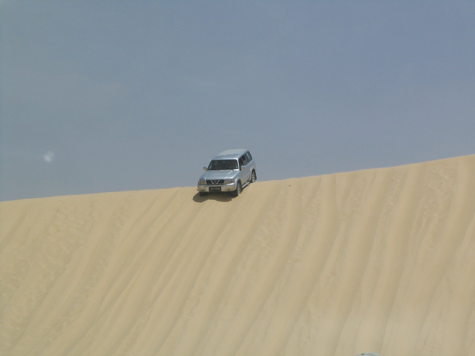 the pickup truck is going up the sand dunes