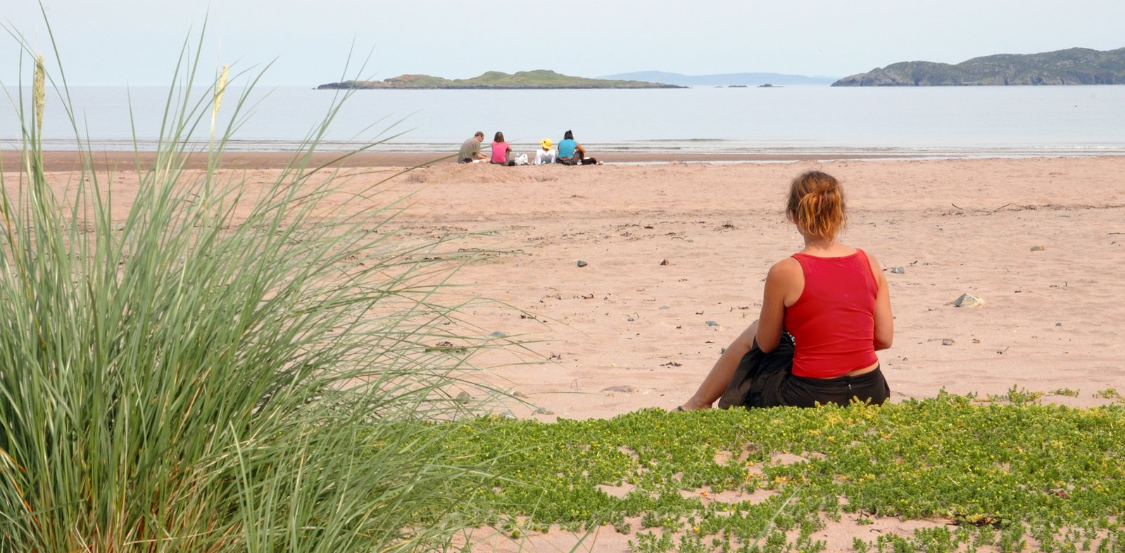 woman looking at boats out on the beach