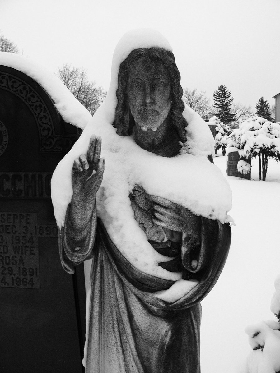 black and white pograph of a statue covered in snow