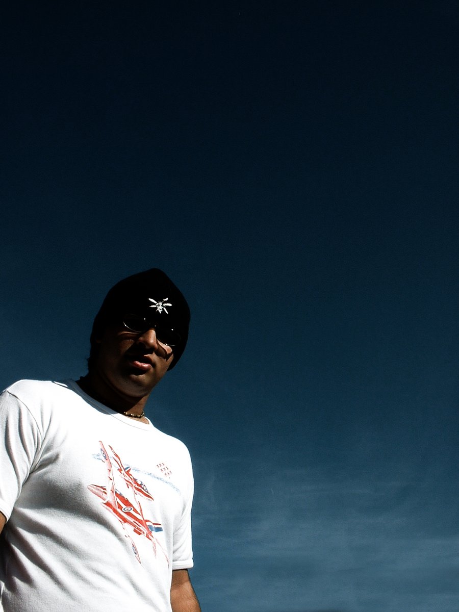 a man holding onto a snowboard under a blue sky