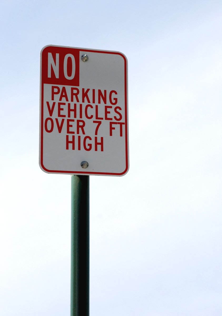 a no parking and vehicles over 7ft sign posted on a street